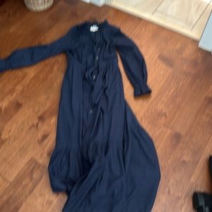 Navy long xirena cotton dress with ruffle neck and ruffle edge on sleeve cuffs.